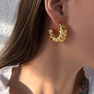 18k gold plated stainless steel hollow twisted hoop earrings worn by a model