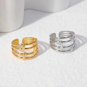 Detail view of gold and silver geometric hollow layered open rings on a white background