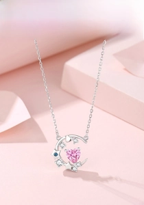 Macro shot of S925 silver crescent moon necklace with a pink heart-shaped zircon stone