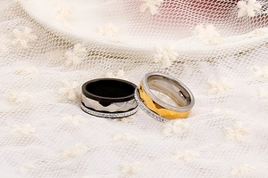 Detail showing wave textured stainless steel couple rings with inlaid diamonds