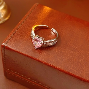 Close-up of pink heart-shaped zircon ring on a vintage leather jewelry box