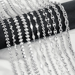 Collection of stainless steel necklaces with various chain styles on white silk fabric