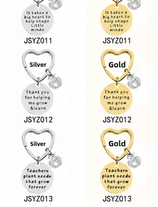 Macro detail of engraved metal teacher gift keychains with heart rings and apple charms