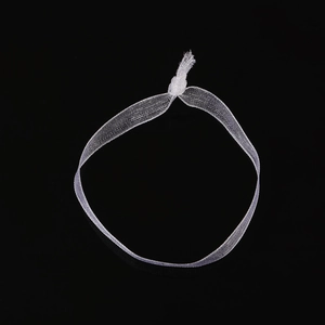 Macro shot of white sheer mesh fabric scrunchie with soft knots on a black background
