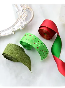 Detailed view of red and green Christmas ribbons in burlap and satin on white plush