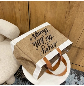 Detail of jute tote bag with enjoy the little things print and leather handles