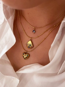 Detail of layered gold necklaces with shell and heart pendants and colored stones