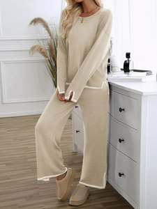 Detail of beige knitted long sleeve top and pants set with contrast white piping detail