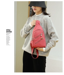 Close-up of pink nylon crossbody chest bag with triple zipper pockets on model