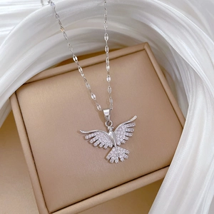 Macro detail of silver eagle pendant with sparkling zircons on a champagne gift box