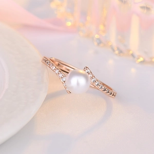 Close-up of rose gold ring featuring a central white pearl and sparkling zircon accents