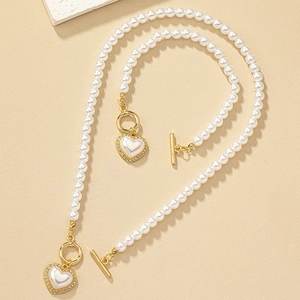 Elegant white pearl necklace with gold heart pendant and sparkling rhinestones