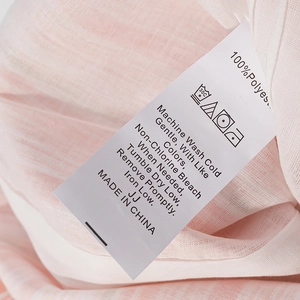 Close-up of pink stripe dress laundry tag showing 100% polyester fabric details