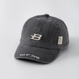 Macro detail of charcoal grey washed cotton baseball cap with ivory 3D embroidery B logo