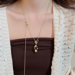 Collier doré avec pendentif étoile et perles porté par un mannequin montrant le détail