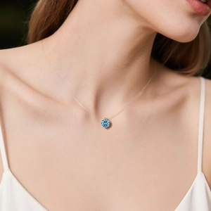 Close-up of a blue gemstone teardrop pendant with multifaceted cut on invisible cord