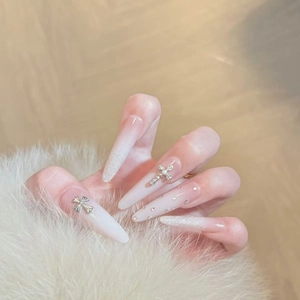 Long stiletto press-on nails with pink white gradient, silver crosses and sparkling crystals
