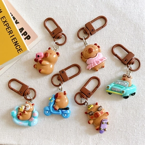 Set of six cute capybara keychains in various poses on white textured fabric background