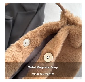 Close-up of the metal magnetic clasp on a brown plush handbag with faux fur texture
