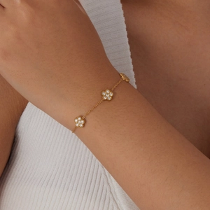 Bracelet floral en acier doré avec cristaux de zircon porté par un mannequin