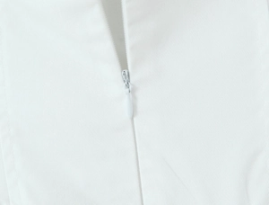 Detailed macro view of high-quality white dress featuring a discreet invisible zipper