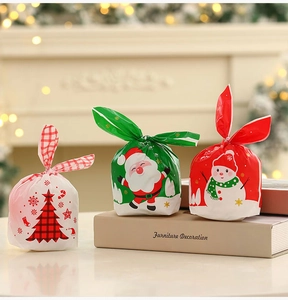 Three festive Christmas gift bags featuring Santa, snowman, and tree patterns with bunny ear ties