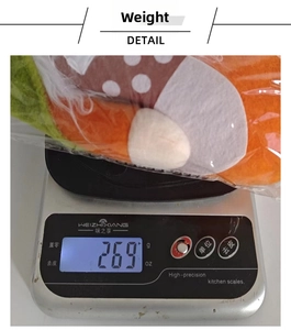 Close-up showing a plush autumn-colored Christmas gnome weighing 269g on a digital scale