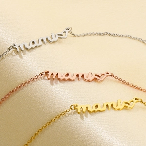 Detail view of heart-shaped mama necklaces in silver, rose gold, and gold finishes