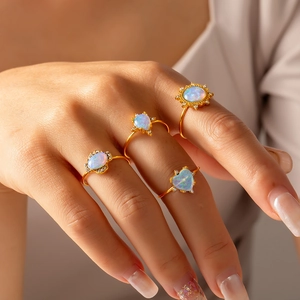 Set of four 18K gold plated opal rings with rhinestones on model's hand