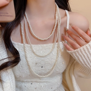 Dettaglio dell'elegante collana di perle bianche a tre strati con finitura lucida