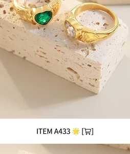 Macro detail of 18K gold-plated rings with heart gems and side engraving on stone