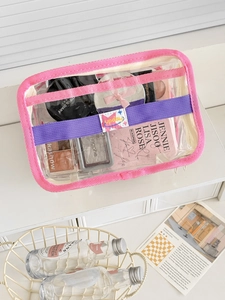 Detail of pink trimmed clear PVC makeup bag showing large capacity and organizer straps