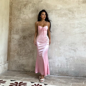 Dettaglio di abito in raso rosa con inserti in pizzo e fiocco decorativo sul petto