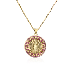 Macro shot of 18K gold plated pendant with pink zircons and religious relief detail