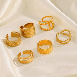 Set of 6 gold plated geometric stainless steel open rings on elegant silk fabric