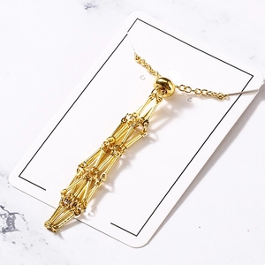 Gold-plated geometric hollow metal cage pendant necklace on a jewelry display card