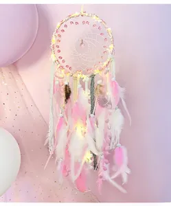 Detail of pink and white dream catcher with LED lights, lace fringe and feathers
