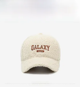 Detail of beige fleece baseball cap featuring GALAXY 1990 brown embroidery texture