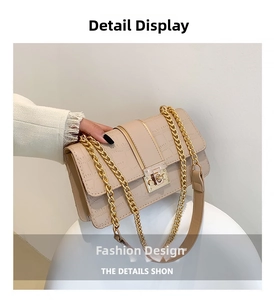 Detail van beige tas met krokodillenprint, gouden ketting en vierkante metalen gesp