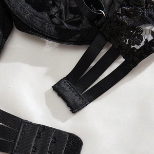 Macro view of the black lace lingerie set back with triple elastic straps and hook closure