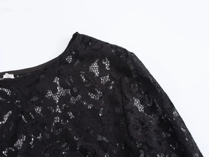 Close-up of elegant black lace texture and crew neckline with intricate patterns