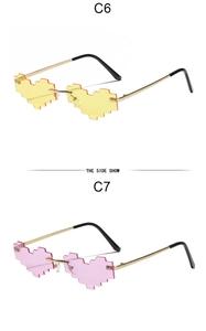 Detail view of heart-shaped pixel sunglasses in yellow and pink with metal frames