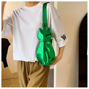 Detail of glossy metallic green cat-shaped bag with adjustable fabric shoulder strap