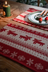 Close-up of red and beige Christmas placemat featuring woven reindeer and snowflake patterns