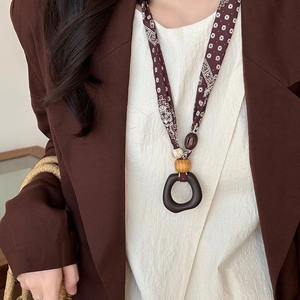 Ethnic wood pendant necklace with floral cord and irregular resin ring charm