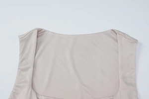 Close-up of square neckline and wide shoulder straps on a beige slim knit tank top