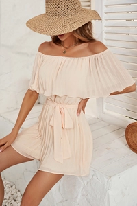 Detail of off-shoulder pleated romper in apricot with waist tie and summer accessories