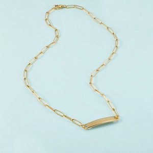 Polished gold rectangular pendant necklace with paperclip chain links on blue background