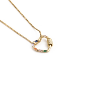 Detail of a golden heart pendant necklace featuring colorful rainbow square gemstones