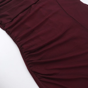 Détail macro des fronces latérales sur une robe en maille bordeaux fendue